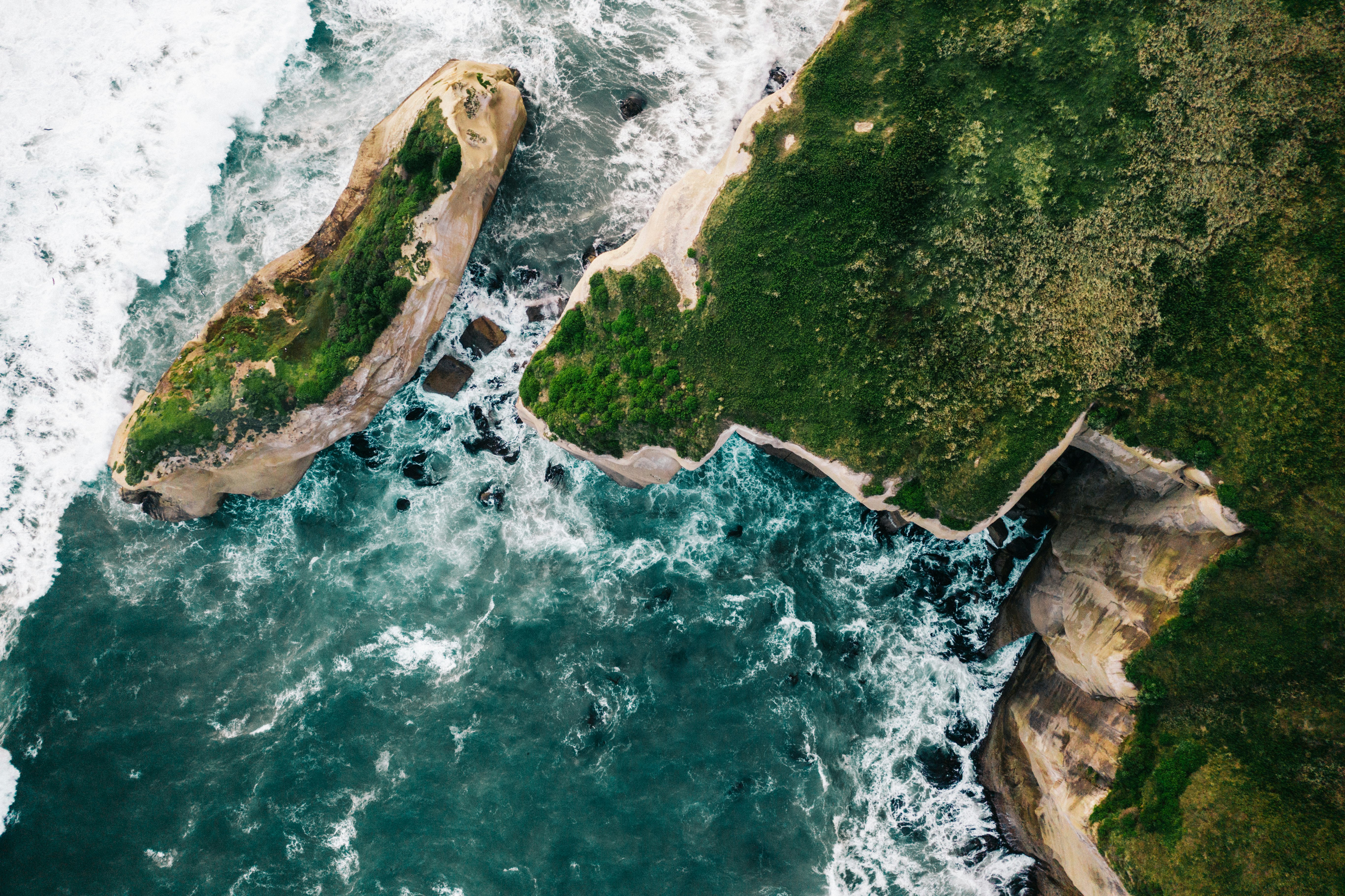 brown rock formation beside body of water during daytime